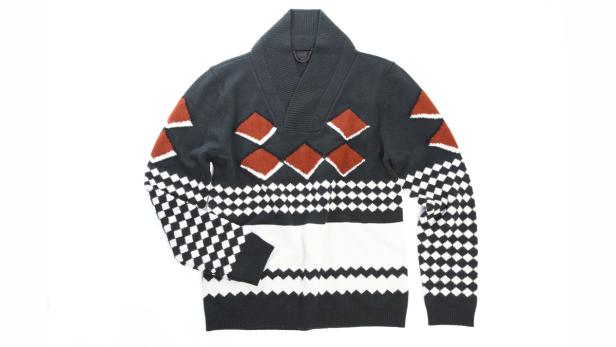 Ein grauer Strickpullover mit geometrischen Mustern in Weiß, Schwarz und Orange.