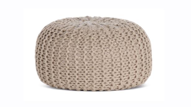 Ein beiger, gestrickter Pouf auf einem weißen Hintergrund.