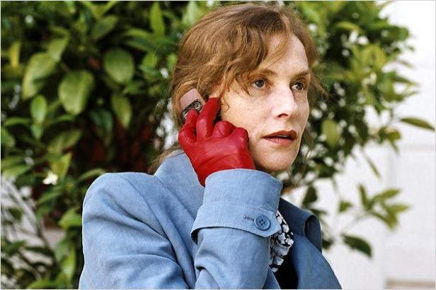 Isabelle Huppert telefoniert mit einem roten Handschuh am Ohr.