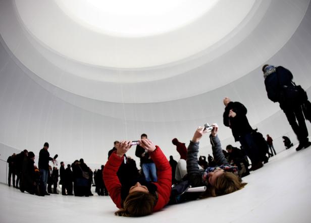 Besucher fotografieren in einem großen, weißen Kuppelbau.