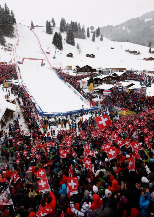 Eine Menschenmenge schwenkt Schweizer Flaggen bei einem Ski-Weltcup-Rennen.