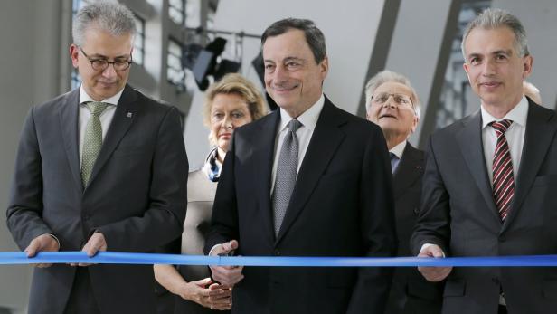 Mario Draghi schneidet bei einer feierlichen Veranstaltung ein blaues Band durch.