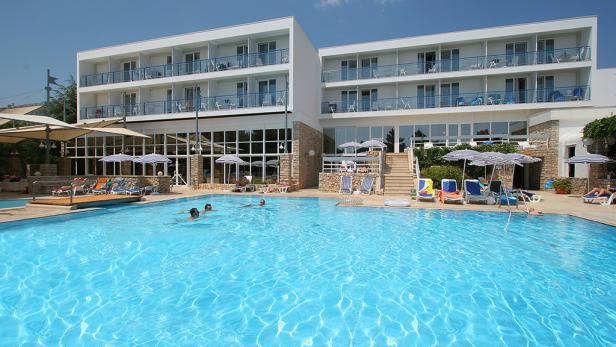 Ein Hotel mit Swimmingpool, in dem mehrere Personen schwimmen.