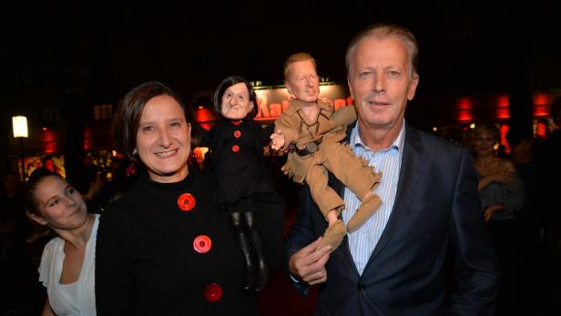 Zwei Personen posieren mit Puppen, die Angela Merkel und Winnetou darstellen.