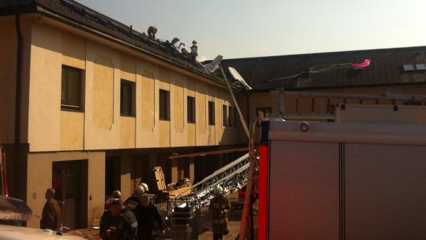 Ein Flugzeug ist auf dem Dach eines Gebäudes abgestürzt, Feuerwehrleute sind vor Ort.