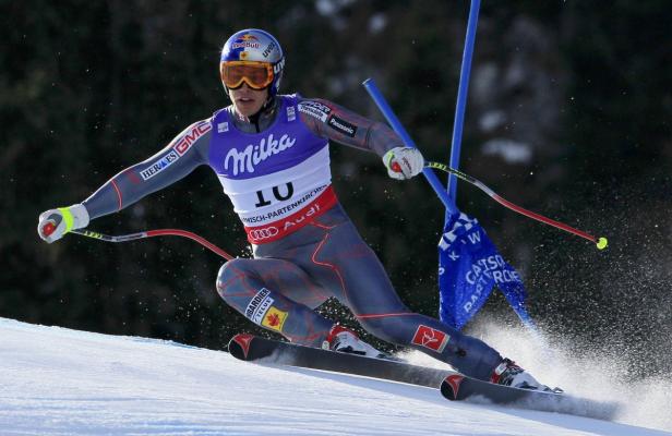 Ein Skirennfahrer rast mit hoher Geschwindigkeit eine schneebedeckte Piste hinunter.