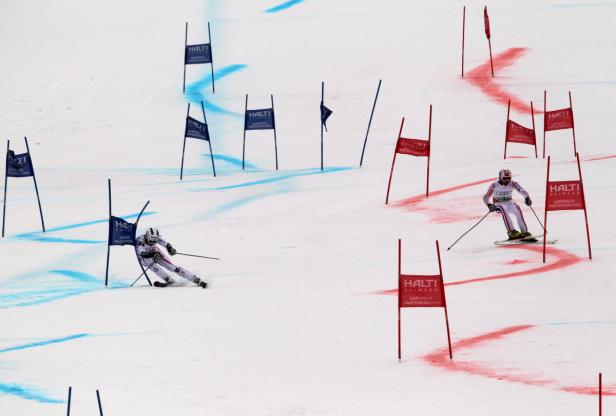 Zwei Skirennläufer während eines Slalomrennens auf einer schneebedeckten Piste.