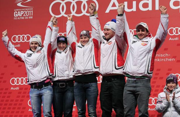 Eine Gruppe Skirennläufer jubelt auf dem Podium in Garmisch-Partenkirchen.