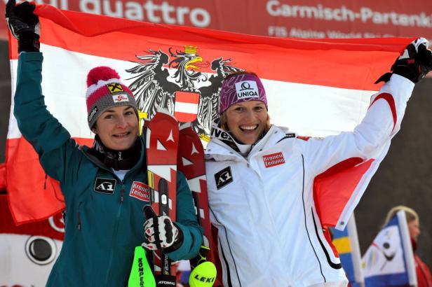 Zwei Skirennläuferinnen feiern mit der österreichischen Flagge.