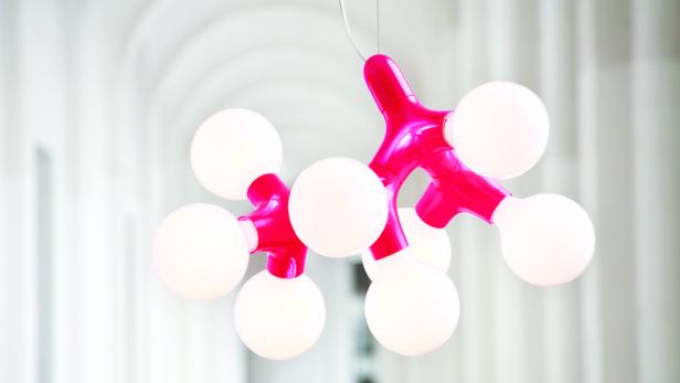 Eine pinkfarbene Molekül-Lampe mit mehreren runden, weißen Glühbirnen hängt von der Decke.