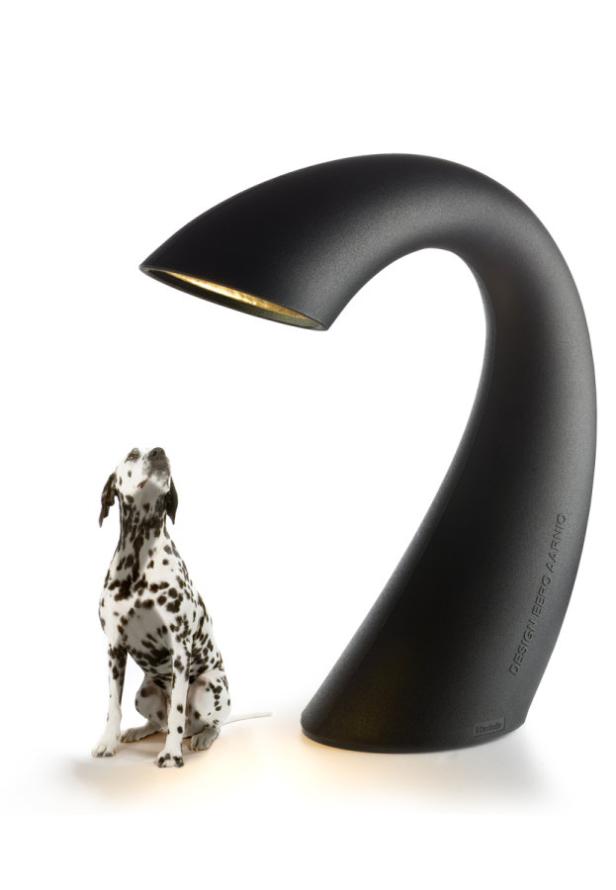 Ein Dalmatiner sitzt neben einer schwarzen Lampe des Designers Eero Aarnio und schaut nach oben.