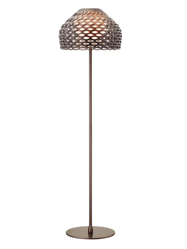 Eine bronzefarbene Stehlampe mit einem Lampenschirm aus einem wabenförmigen Muster.