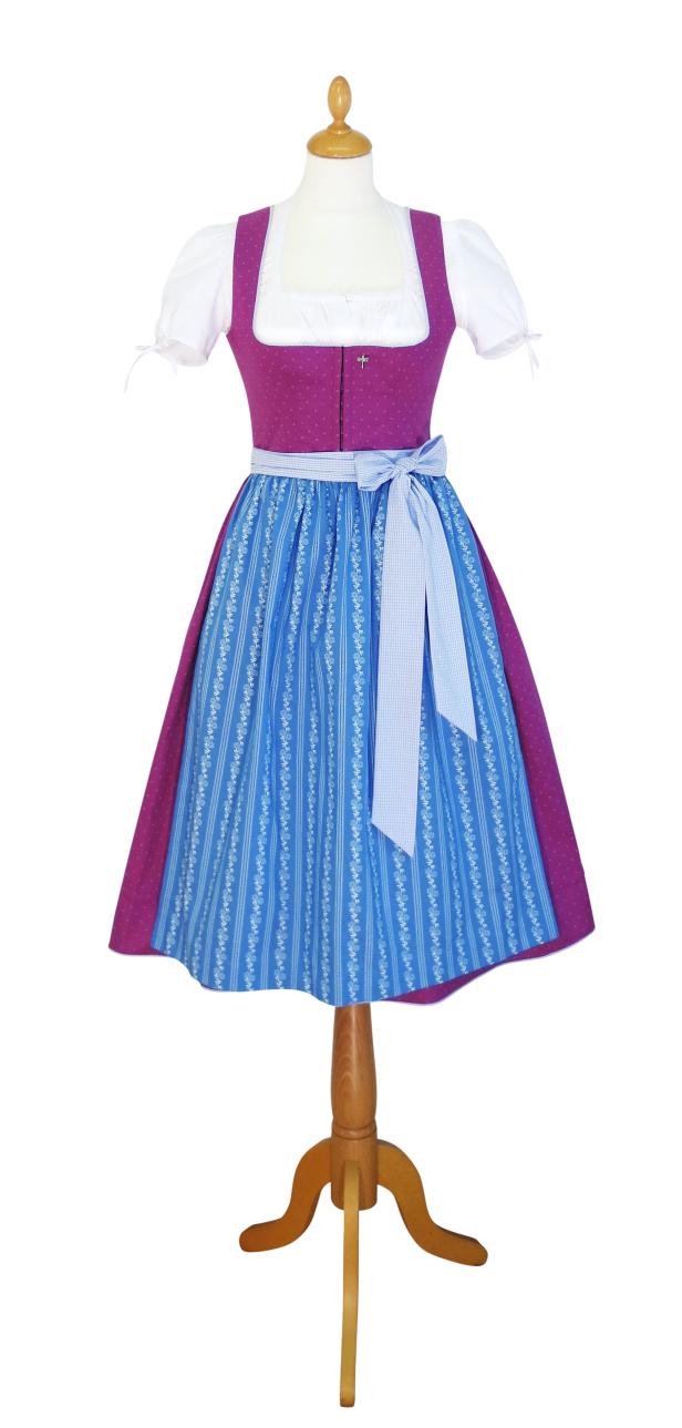 Ein Dirndl mit lila Oberteil, blauem Rock und weißer Schürze auf einer Schneiderpuppe.