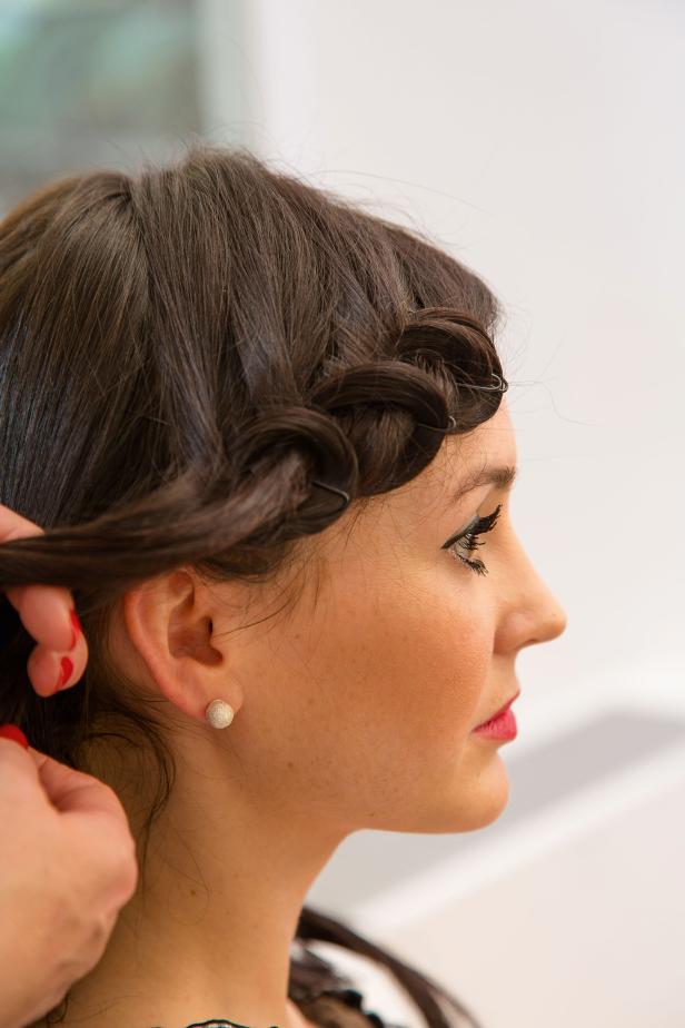 Eine Frau mit braunen Haaren bekommt eine geflochtene Frisur.