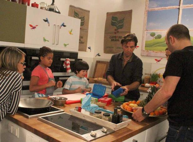 Eine Gruppe von Menschen bereitet in einer Küche Mahlzeiten zu.