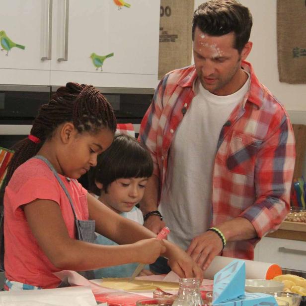 Ein Mann und zwei Kinder backen gemeinsam in einer Küche.