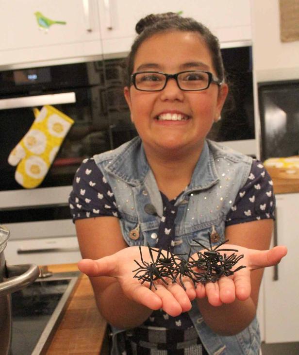 Ein Mädchen hält Spielzeugspinnen in ihren Händen.