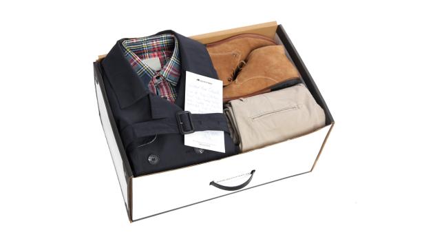 Ein Outfit mit Jacke, Hemd, Hose und Schuhen in einer weißen Box.