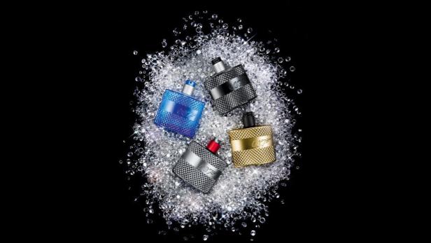 Vier Flakons des James-Bond-007-Duftes liegen auf einem Haufen glitzernder Diamanten.