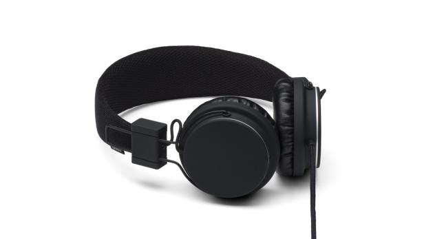 Ein schwarzer kabelgebundener Kopfhörer liegt auf einer weißen Oberfläche.