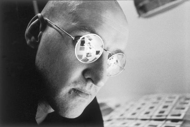 Ein Mann mit Brille betrachtet Kontaktabzüge.