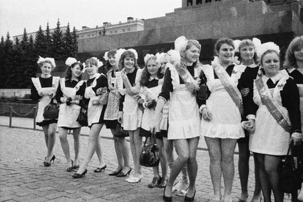 Eine Gruppe junger Frauen in Schuluniformen steht auf einem Platz.