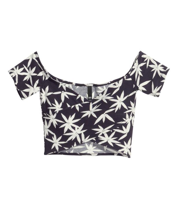 Ein kurzärmeliges, bauchfreies Oberteil mit einem weißen Blumenmuster auf dunklem Grund.