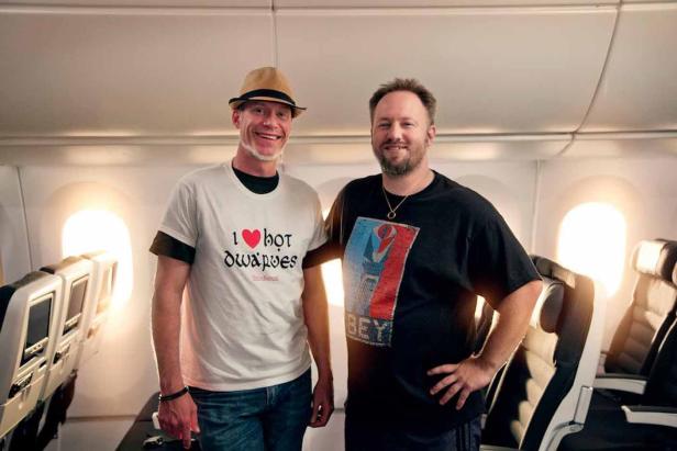 Zwei Männer stehen in einem Flugzeug nebeneinander.