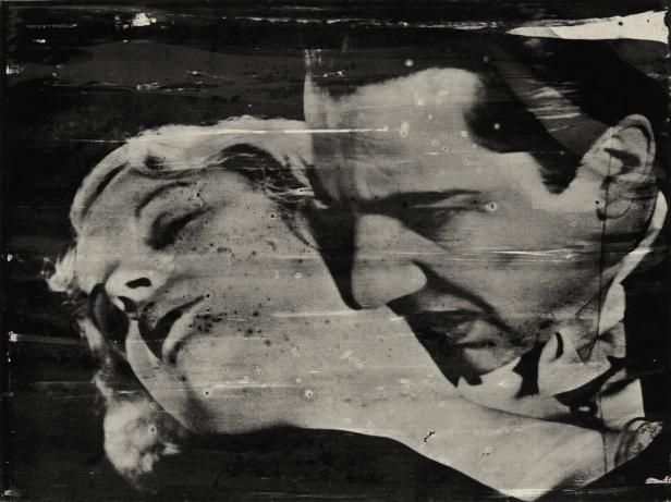 Ein Mann beugt sich zu einer Frau in einer Schwarzweißaufnahme.