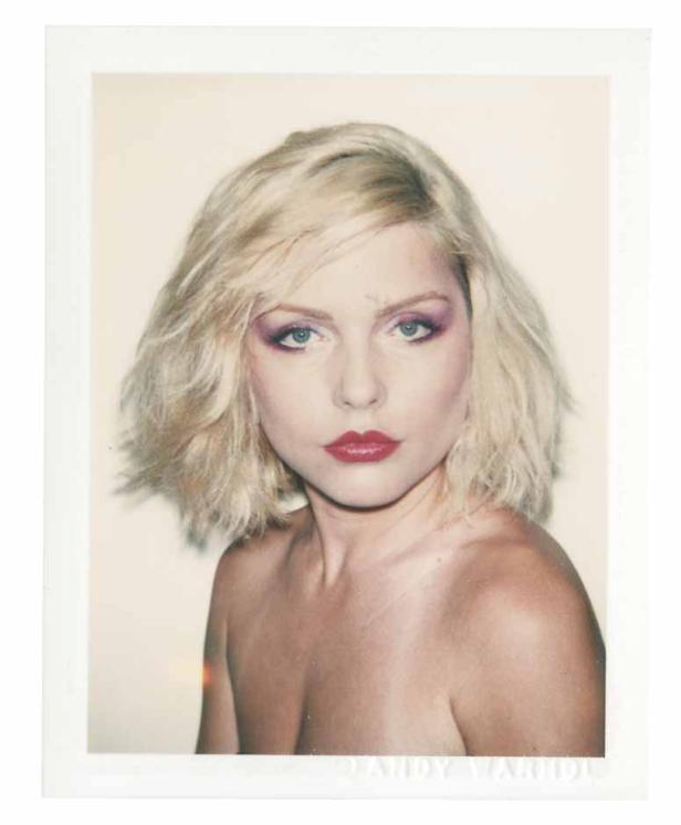 Ein Porträt von Debbie Harry mit blonden Haaren und rotem Lippenstift.