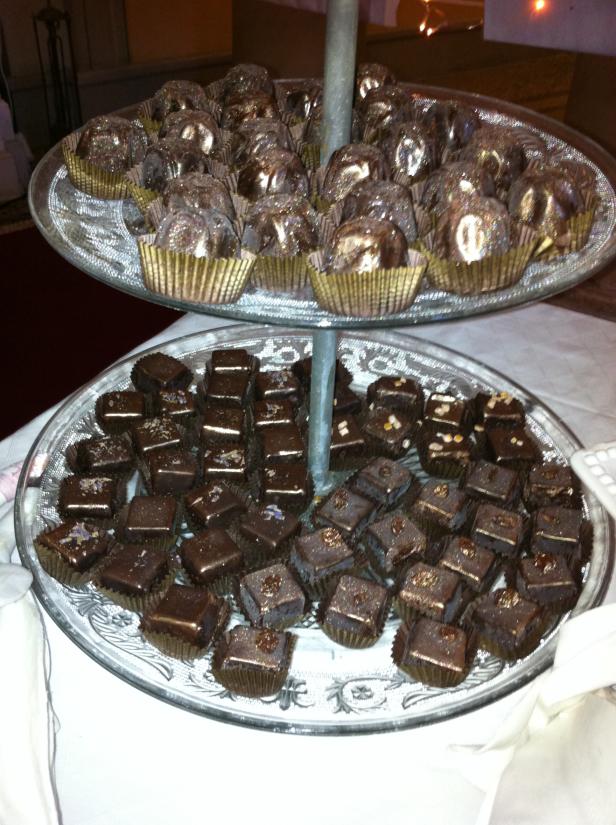 Ein zweistöckiger Servierständer gefüllt mit Pralinen und Schokoladenwürfeln.