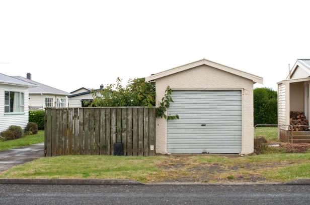 Eine Garage und ein Holzzaun in einer Vorstadtsiedlung.