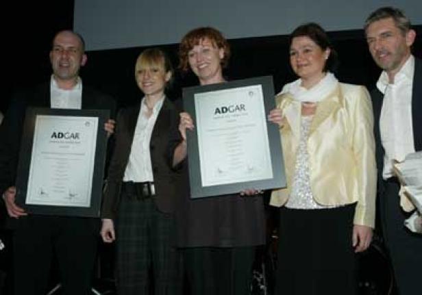 Eine Gruppe von Personen hält ADGAR-Auszeichnungen in der Hand.