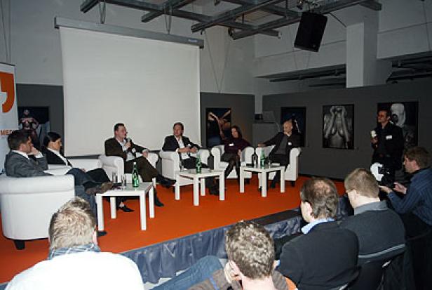 Eine Podiumsdiskussion mit mehreren Personen vor Publikum.