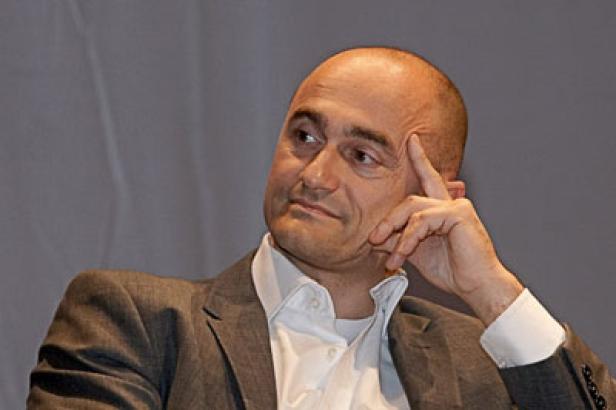 Ein Mann im Anzug blickt nachdenklich zur Seite.