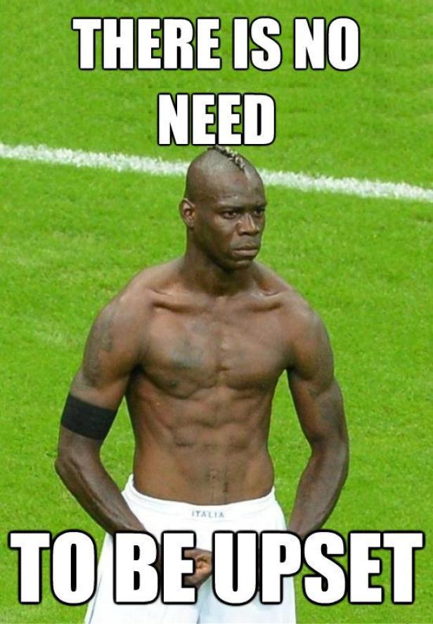 Mario Balotelli steht mit freiem Oberkörper auf einem Fußballfeld.