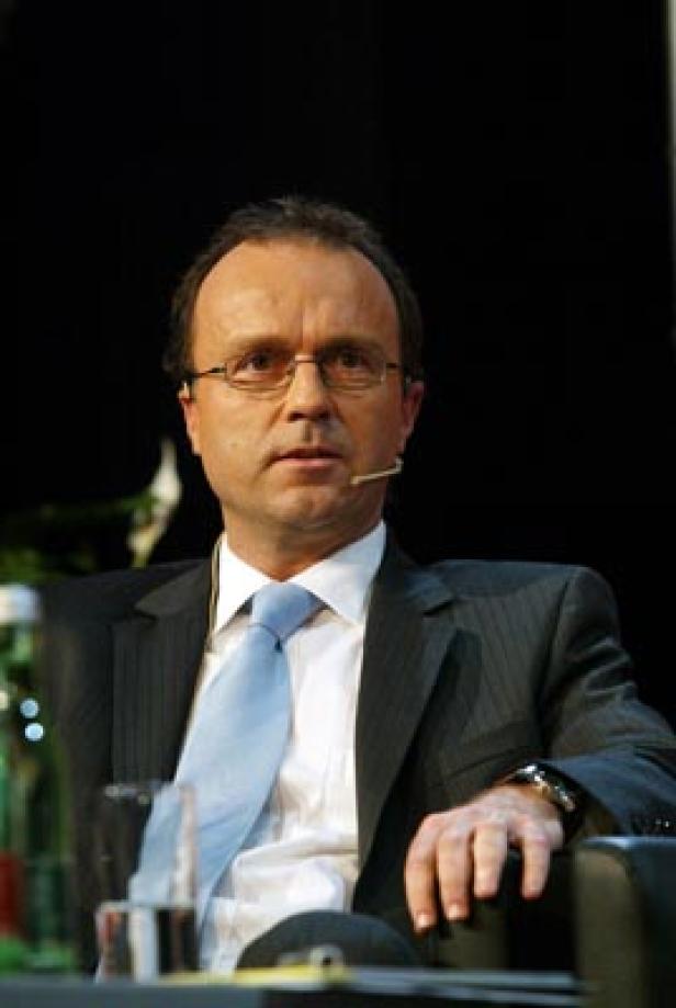 Ein Mann mit Brille und Anzug spricht bei einer Veranstaltung.