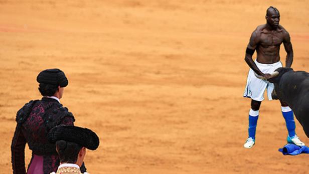 Ein Fußballspieler steht einem Stier in einer Arena gegenüber, während zwei Matadore zusehen.