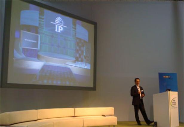 Ein Mann hält eine Präsentation vor einer Leinwand mit dem IP-Logo.