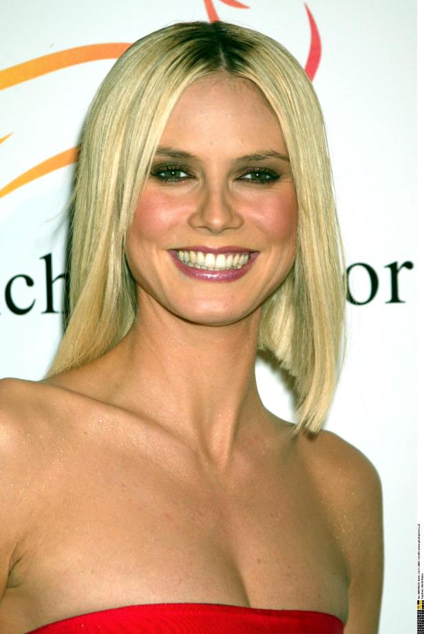 Ein Porträt von Heidi Klum mit blonden Haaren und einem roten Kleid.