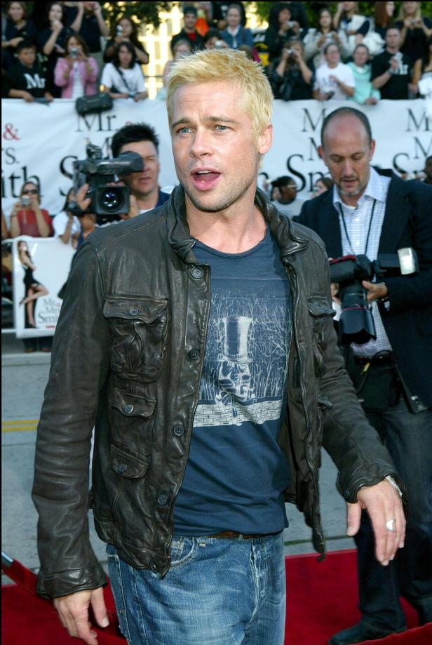 Brad Pitt auf einem roten Teppich, mit blonder Kurzhaarfrisur und Lederjacke.