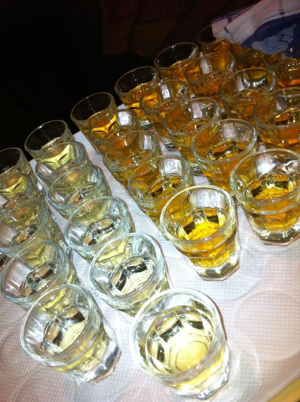 Viele Schnapsgläser stehen auf einem Tablett.