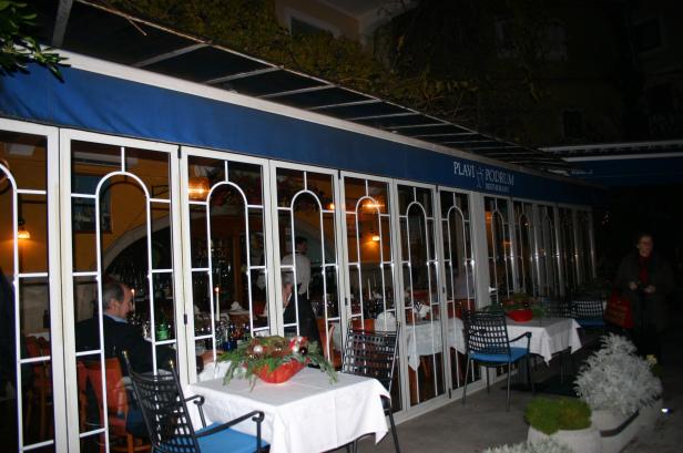Das Restaurant „Plavi Podrum“ mit gedeckten Tischen am Abend.