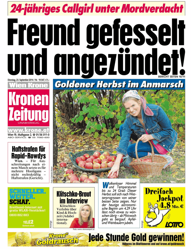 Eine Frau erntet Äpfel in einem Korb im Herbstlaub.