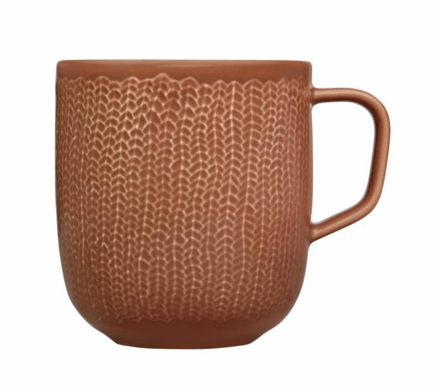 Eine braune Tasse mit einem Strickmuster.