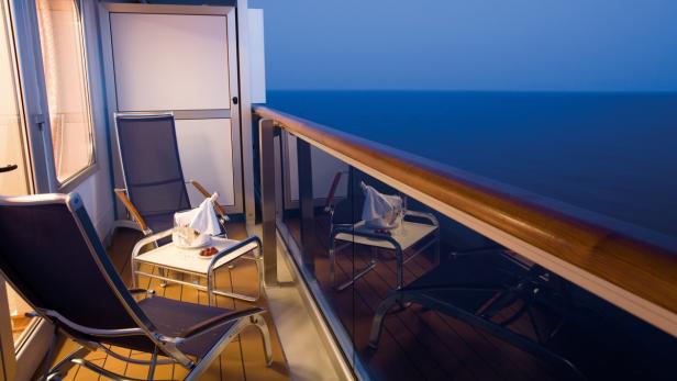 Ein Balkon mit Meerblick, ausgestattet mit Stühlen, Tisch und Champagnerkübel.