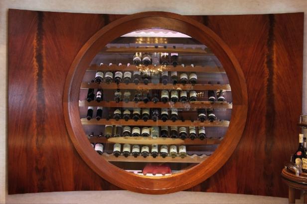 Ein runder Weinkühlschrank ist in eine hölzerne Wand eingelassen.