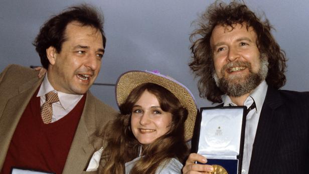 Ralph Siegel wird 70 Drei Personen posieren mit Medaillen, darunter eine Frau mit Hut.