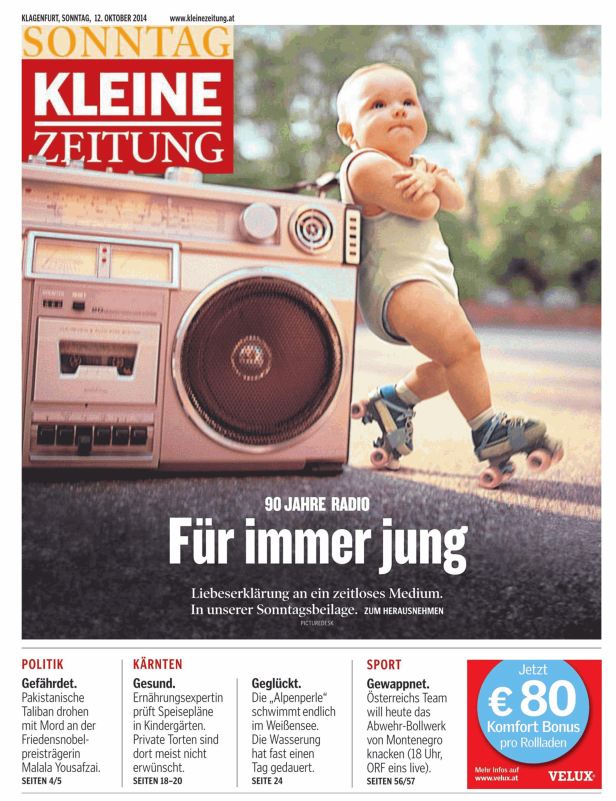 Ein Baby auf Rollschuhen steht vor einem alten Ghettoblaster.
