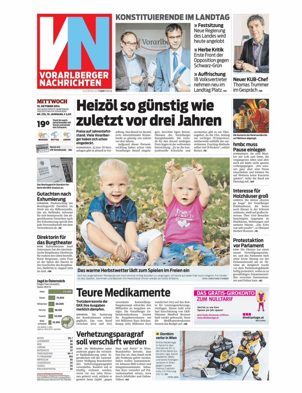 Zwei kleine Mädchen spielen im Herbstlaub im Freien.